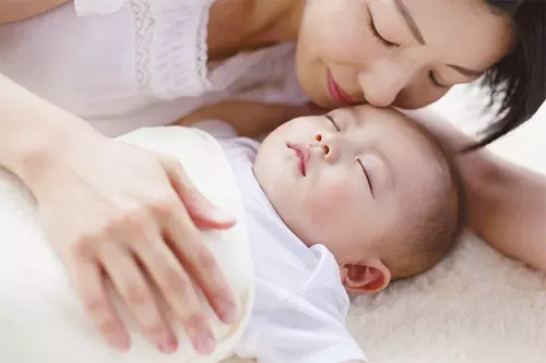 眠る赤ちゃんとお母さん